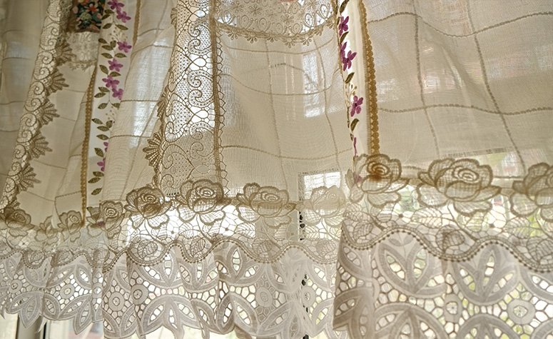 An intriguing corner of a vintage 100% cotton embroidered lace curtain