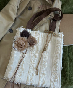 Rustic floral canvas tote bag with beige and brown fabric roses, brown suede strap, and rope tie closure.